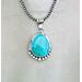 Front hanging view large blue turquoise pear cabochon bezel set accented with beads and stamped wire on oxidized navajo pearls 